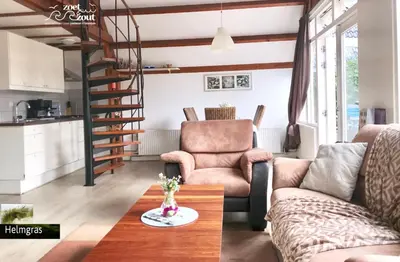a living room with a couch and a table at Holiday-Home HELMGRAS 5p. Amsterdam and the beach in Opmeer