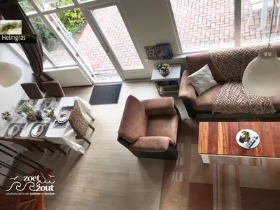 a living room with a couch and a table at Holiday-Home HELMGRAS 5p. Amsterdam and the beach in Opmeer