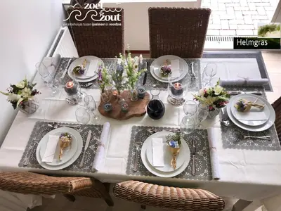a table with plates of food and flowers on it at Holiday-Home HELMGRAS 5p. Amsterdam and the beach in Opmeer