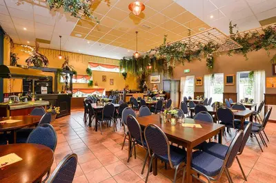 a dining room with wooden tables and chairs at Holiday-Home HELMGRAS 5p. Amsterdam and the beach in Opmeer