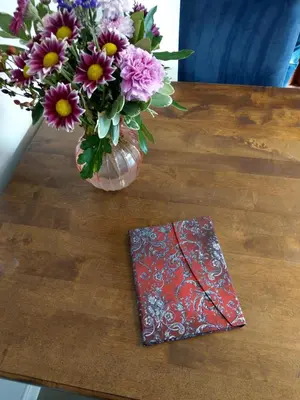 a vase of flowers and a napkin on a table at B&B De Blauwe Tulp in Noord-Scharwoude