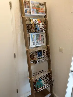 a book shelf in a hallway with books and magazines at B&B De Blauwe Tulp in Noord-Scharwoude