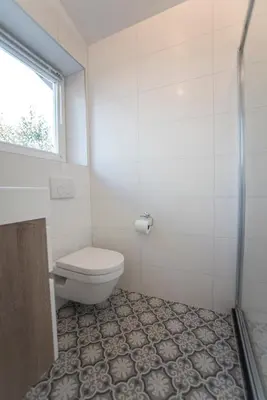 a bathroom with a toilet and a window at New Point in Zandvoort
