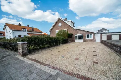 a brick house with a fence and a driveway at New Point in Zandvoort