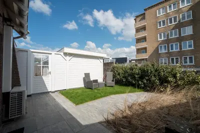 a garden with two chairs and a building at New Point in Zandvoort