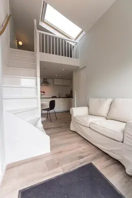 a living room with a white couch and a skylight at New Point in Zandvoort
