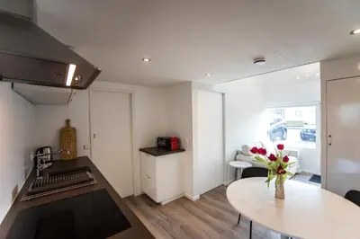 a kitchen with a vase of flowers on a table at New Point in Zandvoort
