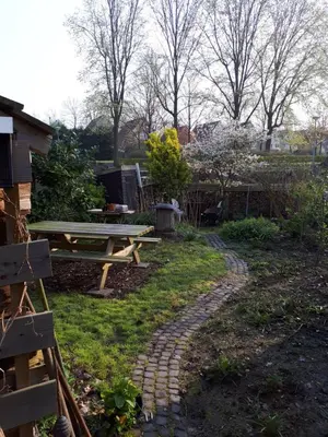 a garden with a picnic table and a stone path at Klavergeluk in Amsterdam