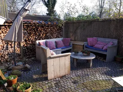 a patio with two couches and a table and an umbrella at Klavergeluk in Amsterdam