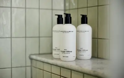 a group of four shampoo bottles sitting on a shelf in a bathroom at The July - Boat & Co in Amsterdam