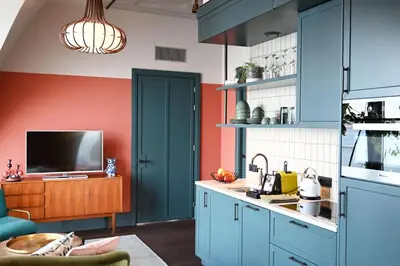a kitchen with blue cabinets and a tv at The July - Boat & Co in Amsterdam