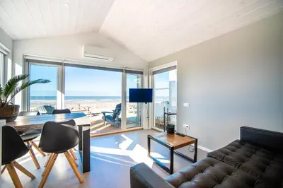 a living room with a couch and a view of the ocean at BUDDHA BEACH BUNGALOWS Adults Only in Zandvoort