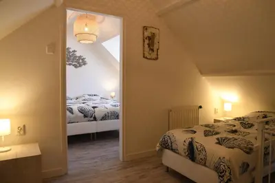 a attic bedroom with two beds and a mirror at Bleyendaal aan Zee in Egmond aan Zee