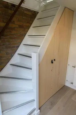 a staircase in a loft with a wooden door at Bleyendaal aan Zee in Egmond aan Zee