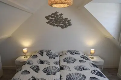 a bedroom with a bed and two night stands at Bleyendaal aan Zee in Egmond aan Zee