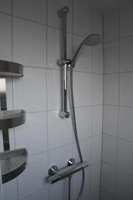 a shower with a shower head in a bathroom at Bleyendaal aan Zee in Egmond aan Zee
