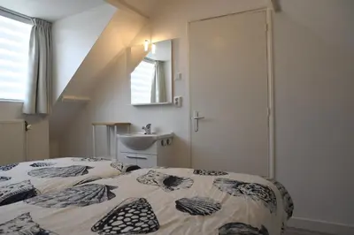 a bedroom with two beds and a sink in it at Bleyendaal aan Zee in Egmond aan Zee