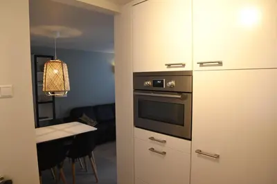 a kitchen with an oven and a table in a room at Bleyendaal aan Zee in Egmond aan Zee