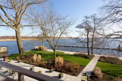 a park next to the water with trees and benches at Restaurant-Hotel de Watergeus in Noorden