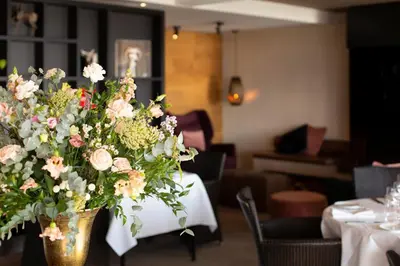 a vase of flowers on a table in a restaurant at Restaurant-Hotel de Watergeus in Noorden