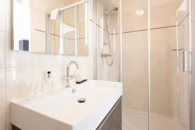 a white bathroom with a sink and a shower at Restaurant-Hotel de Watergeus in Noorden