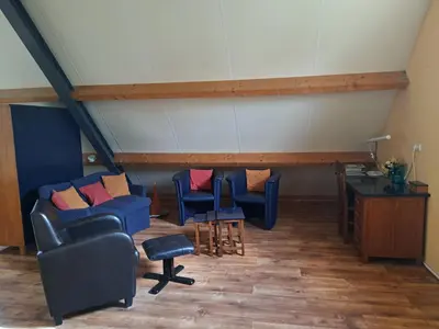 a room with blue chairs and a table and a desk at de Boomgaard Groene Hart in Polsbroekerdam
