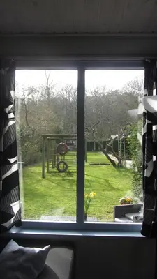 a window with a view of a yard outside at Vakantiehuis Duin Bos en Zee in Schoorl
