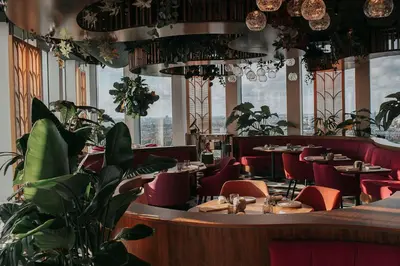 a restaurant with tables and chairs and potted plants at nhow Amsterdam Rai in Amsterdam