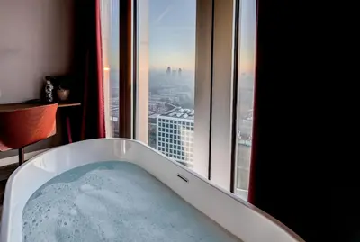 a bath tub in a room with a window at nhow Amsterdam Rai in Amsterdam