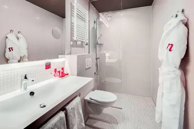 a white bathroom with a sink and a toilet at nhow Amsterdam Rai in Amsterdam