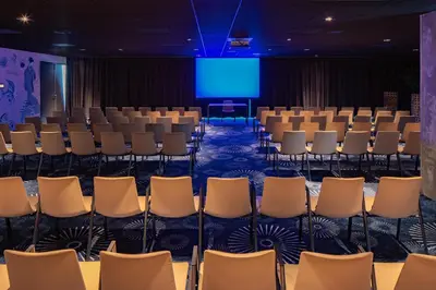 a conference room with chairs and a blue screen at nhow Amsterdam Rai in Amsterdam