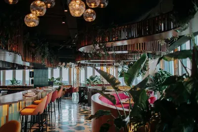 a restaurant with tables and chairs and potted plants at nhow Amsterdam Rai in Amsterdam