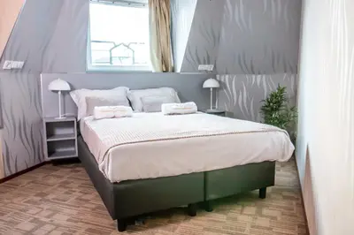 a bedroom with a large bed with two pillows at Golden Zaan Hotel, Zaandam-Amsterdam in Zaandam