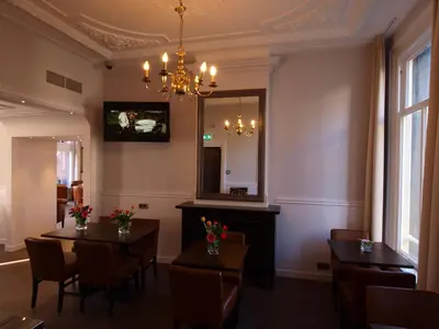 a dining room with two tables and a mirror at Hotel Clemens in Amsterdam