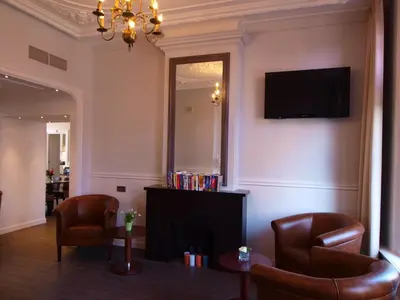 a living room with two chairs and a fireplace at Hotel Clemens in Amsterdam