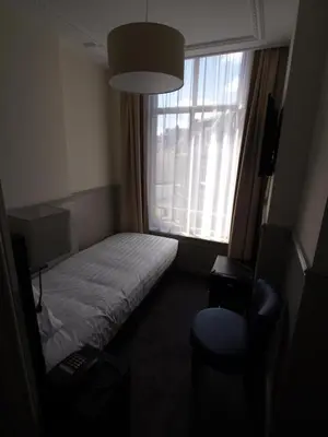 a small room with a bed and a window at Hotel Clemens in Amsterdam