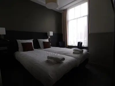 a bedroom with a large bed with two towels on it at Hotel Clemens in Amsterdam