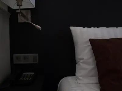 a bedroom with a bed with a pillow and a lamp at Hotel Clemens in Amsterdam