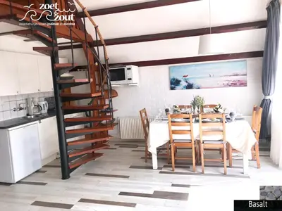 a dining room with a table and a spiral staircase at Holiday Home BASALT 6 p Amsterdam and the beach in Opmeer