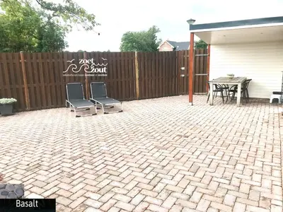 a patio with two chairs and a table and a fence at Holiday Home BASALT 6 p Amsterdam and the beach in Opmeer