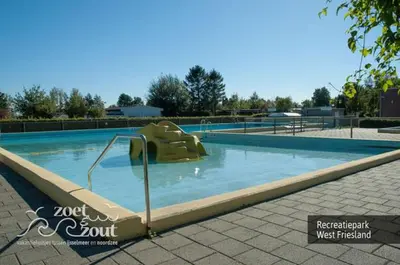 a swimming pool with a slide in the water at Holiday Home BASALT 6 p Amsterdam and the beach in Opmeer