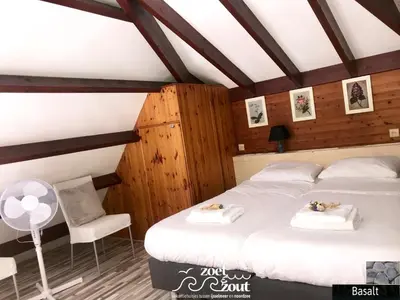 a bedroom with two beds and a chair at Holiday Home BASALT 6 p Amsterdam and the beach in Opmeer
