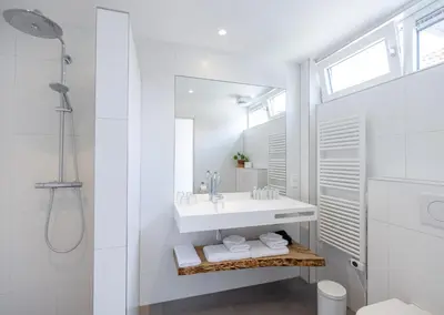 a white bathroom with a sink and a mirror at Villa de Hazelaar in Schoorl