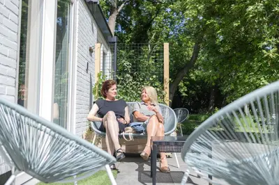 a man and woman sitting on a patio at Villa de Hazelaar in Schoorl