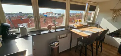 a kitchen with a table and some windows at Sunnyzandvoort in Zandvoort