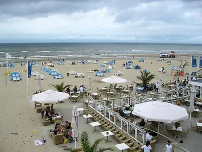 a beach with umbrellas and people on the beach at Sunnyzandvoort in Zandvoort