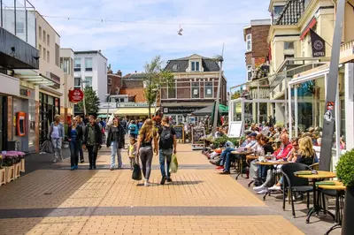 a group of people walking down a busy city street at Sunnyzandvoort in Zandvoort