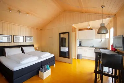 a bedroom with a bed and a desk and a kitchen at Centre beach lodge in Zandvoort