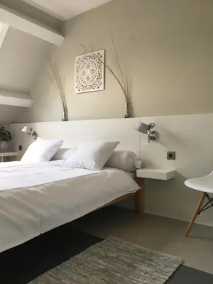 a bedroom with a large white bed and a table at Villa 1913 in Bergen