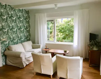 a living room with a couch and a table and a window at Villa 1913 in Bergen